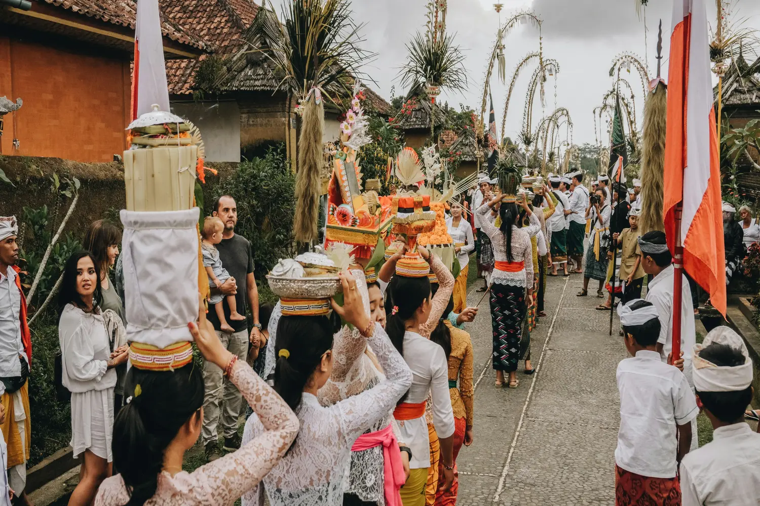 A traditional Balinese Hindu religious procession taking place in Penglipuran Village, Bali, Indonesia