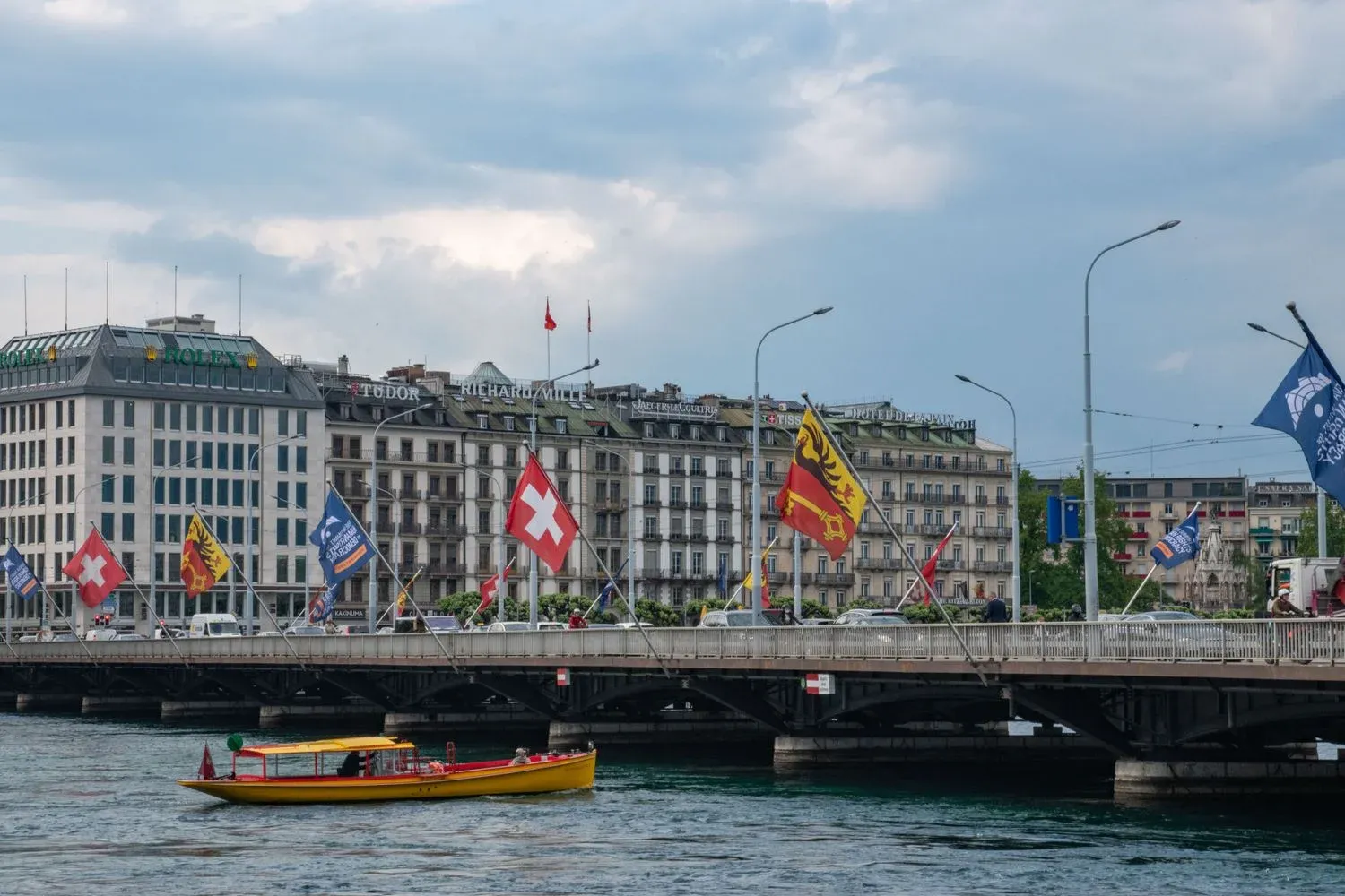 Mont-Blanc Bridge with flags and cityscape in Geneva, Switzerland