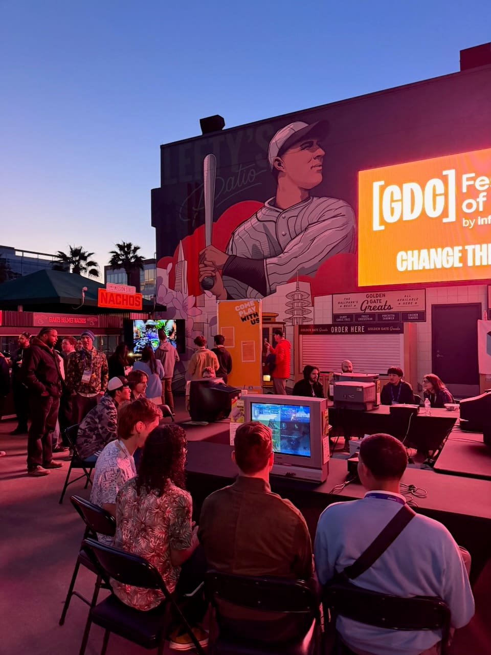 Retro gaming area at dusk with CRT monitors and Giants mural