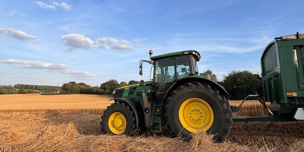 green tractor harvesting hay in the UK