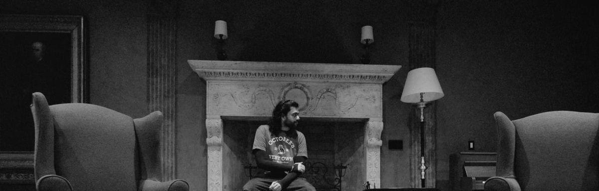 Black-and-white self-portrait of the author seated before a fireplace, framed by two high-backed armchairs.