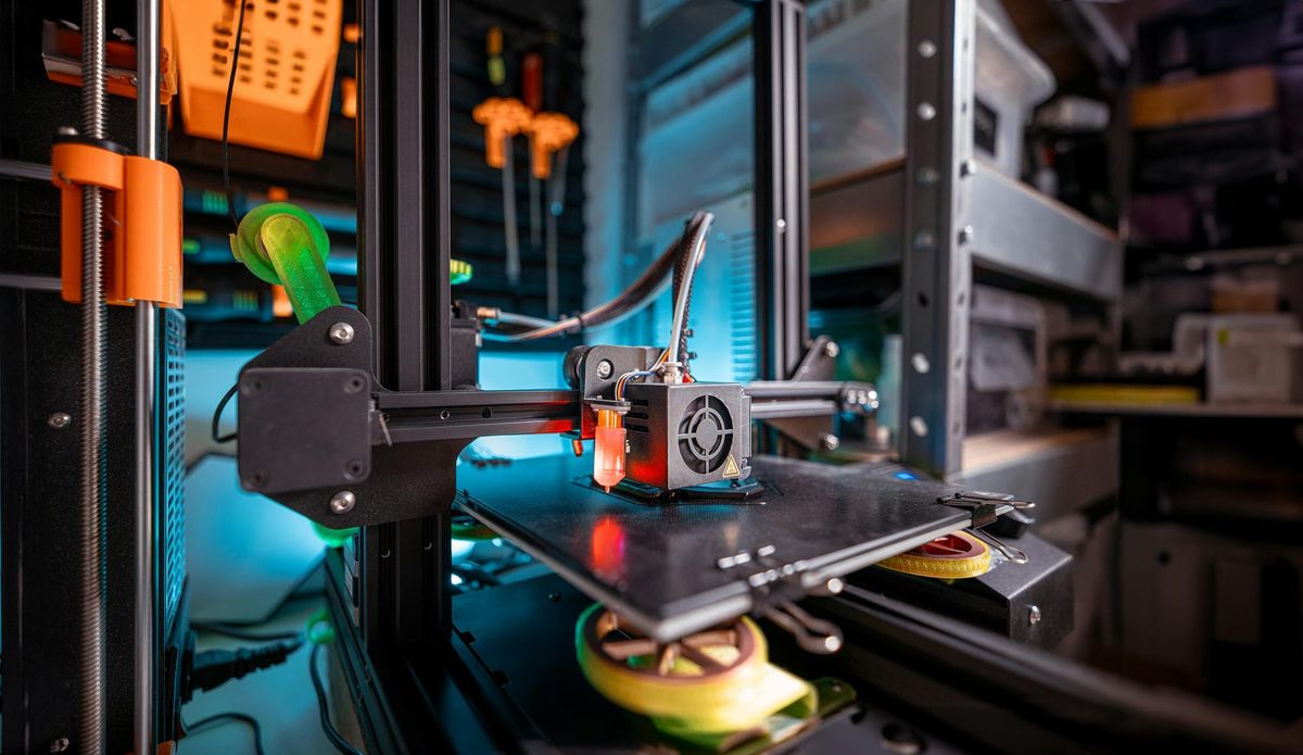 Detailed view of a 3D printer actively working in a workshop environment