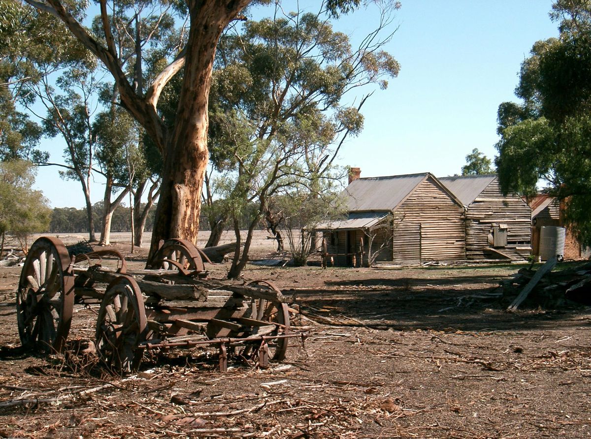 Old farm buildings and rusted equipment on a sunny day in Rushworth, Victoria, Australia.