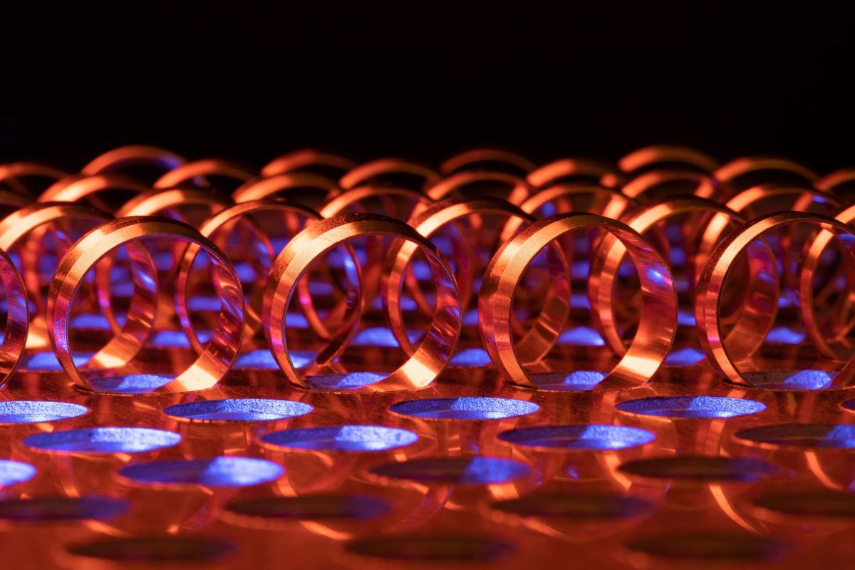 Dynamic abstract photo featuring glowing red rings against a vibrant blue background, creating an energetic pattern.