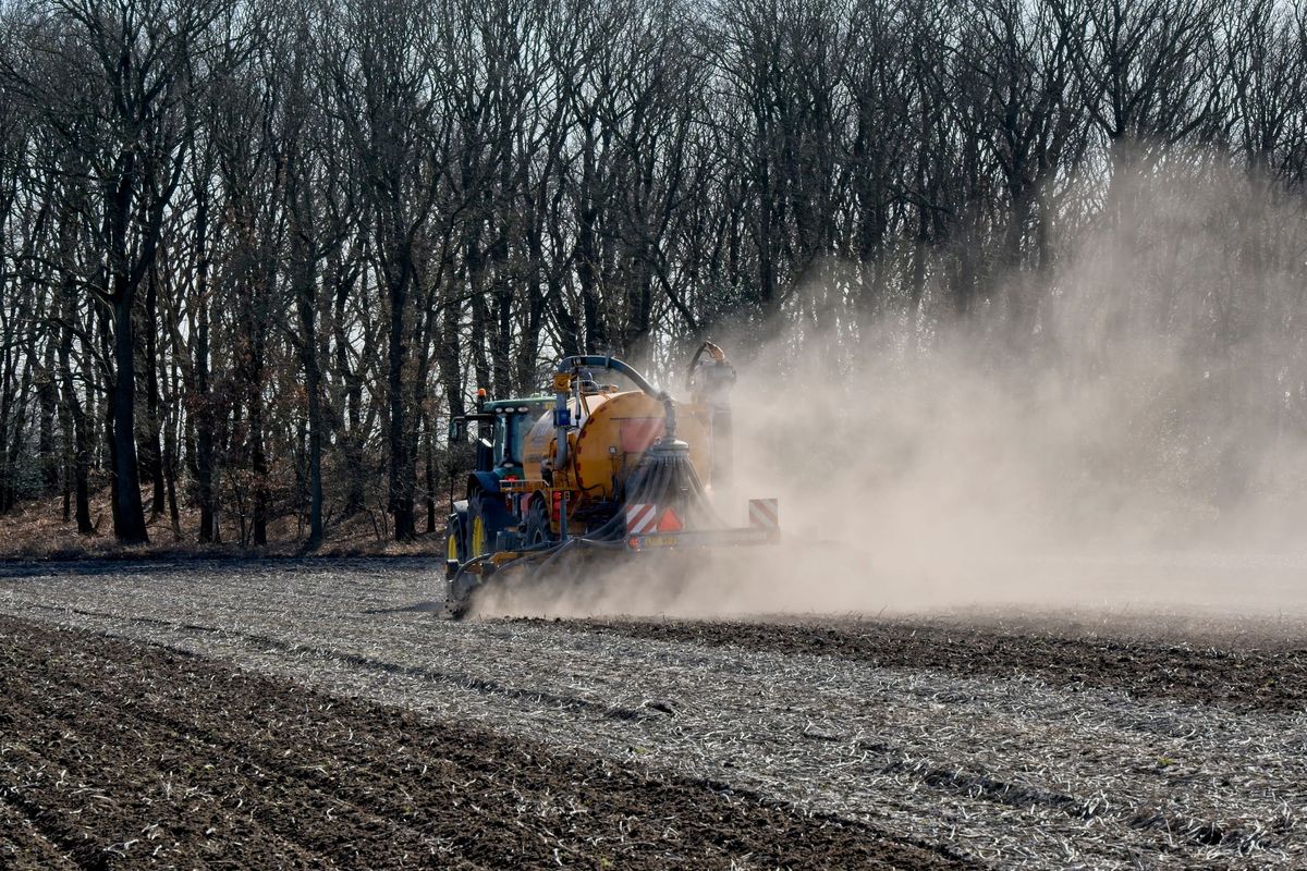 Tractor applying fertilizer on farmland in Drenthe, Netherlands during springtime