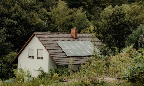 A house with solar panels nestled in a forest