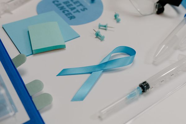 Blue ribbon with medical supplies symbolizes healthcare awareness and cancer support