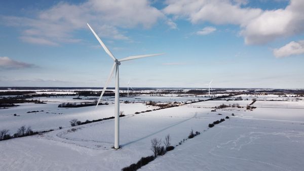 Aerial shot of wind turbines in a snowy landscape in Ontario, Canada, showcasing clean energy in winter.
