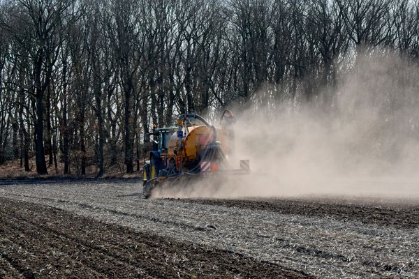 Tractor applying fertilizer on farmland in Drenthe, Netherlands during springtime