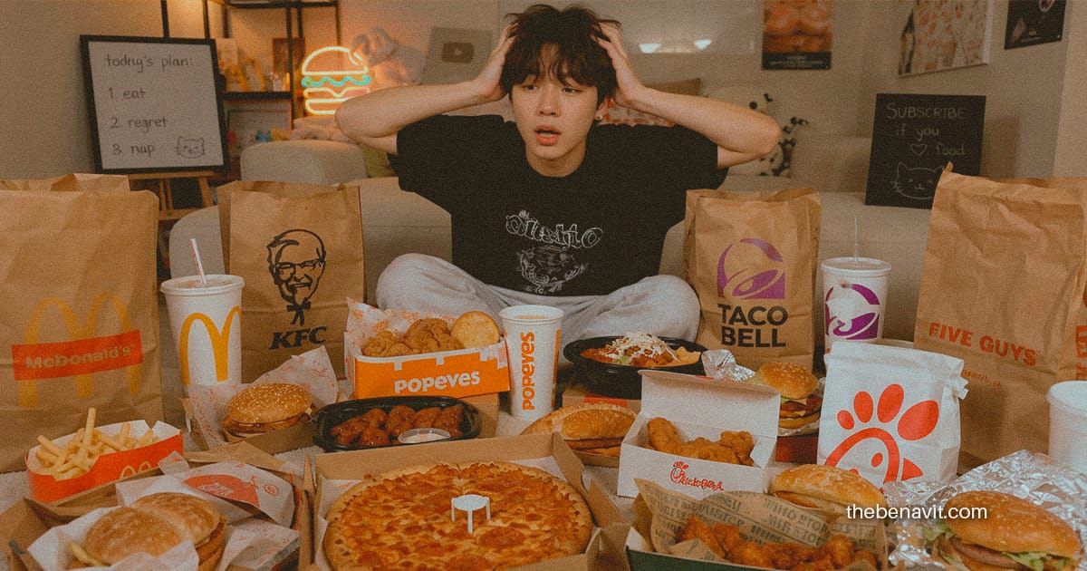 An overwhelmed person surrounded by take-out food ordered impulsively.