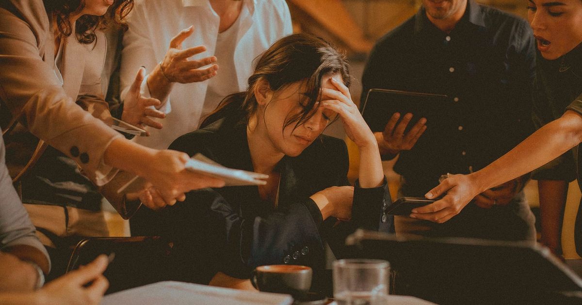 A person sitting exhausted and overwhelmed while people around them demand their attention, capturing the emotional drain of living for everyone else.