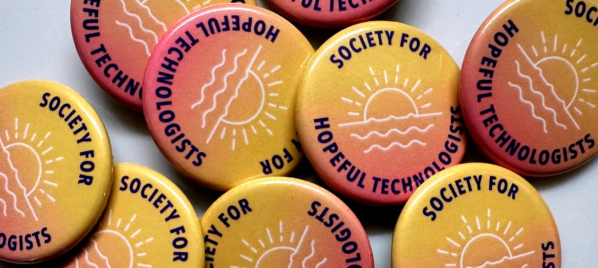 An array of badges saying 'Society for Hopeful Technologists'