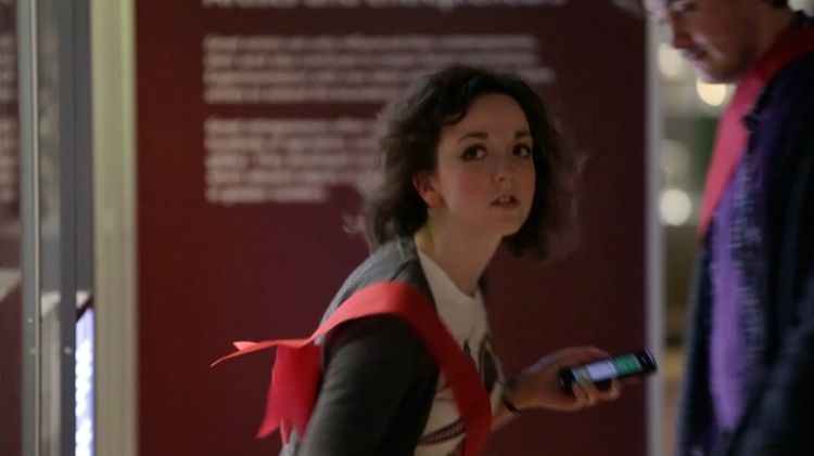 A woman clutches a mobile phone while playing Capture the Museum in the National Museum of Scotland.