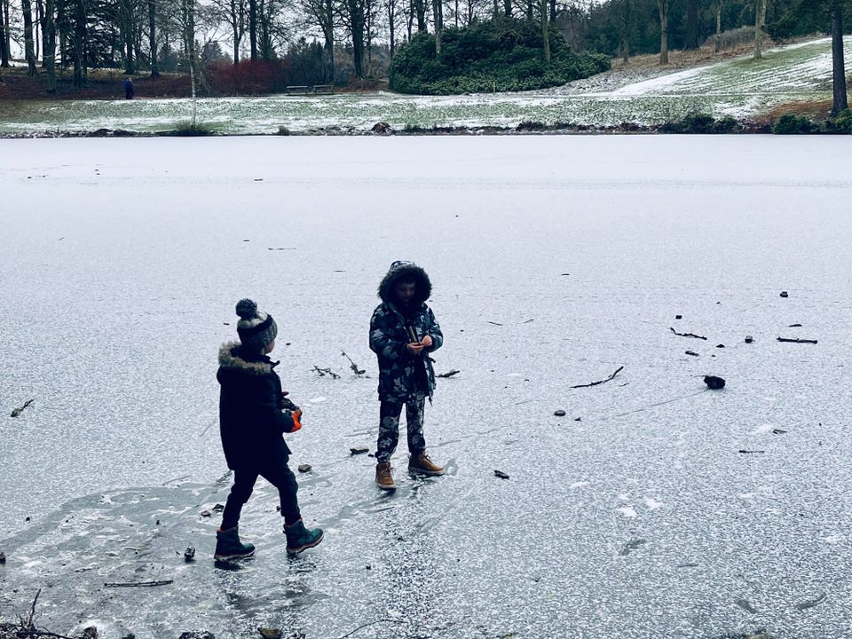 Two boys standing on a frozen loch