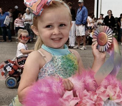 Libby Hartwell holds the blue ribbon she won for the youngest entries in the Doll Carriage Parade in Lubec on July 4. (Chessie Crowe Gartmayer photo)