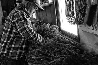 'TIS THE SEASON. Herbie Bishop makes wreaths at Boyden Lake Creative Products’ shop in Perry. Along with decorated wreaths, the shop also sells Christmas trees, baskets, crafts and more. (Ed