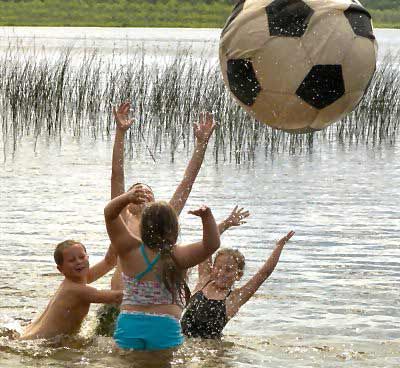 THE SOUNDS OF SUMMER -- giggles and splashes -- can be heard as Adam Olson, 7, Trinity Miliano, 8, Timmy Olson, 11, and Amanda Olson, 6, enjoy a refreshingly cool swim at Round Pond in Charl