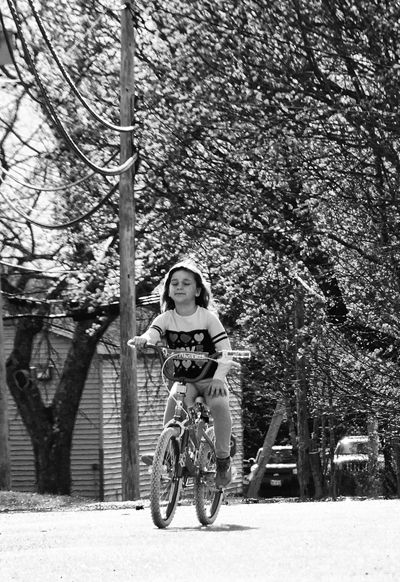 RIDING HER BIKE down a quiet Boynton Street in Eastport late in the afternoon of a May day is Cheyenne Beech, 8, as the leaves are budding out Downeast in the early springtime. (Edward Frenc