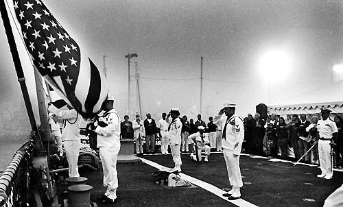 LOWERING THE COLORS at the end of the day on July 4 are members of the USS Porter crew (above). "Look, ma, no hands!" CMC Musso of the Porter seems to be saying in the codfish relay (below).