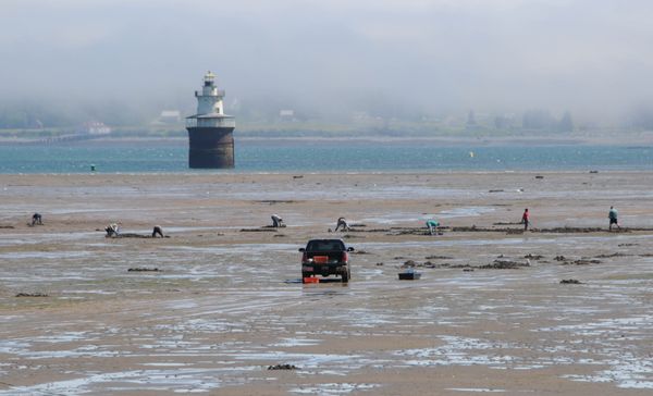 WORKING THE FLATS were a large number of clamdiggers near the Sparkplug lighthouse in the Lubec Channel on July 2, as a fog bank rolls in over West Quoddy Head. The Mowry Beach flats opened 