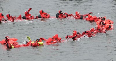 PULLING TOGETHER are nearly 20 fishermen in survival suits who participated in a fishing vessel drill conductor course held May 7 at the U.S. Coast Guard Station in Eastport. The course was 