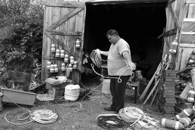 MEASURE TWICE, cut once. Lubec lobsterman James Robbins measures and coils lines by arm’s length to fathoms’ depth for his lobster trap trawl. (Chessie Crowe photo)