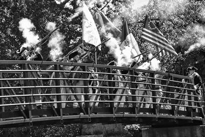 A MUSKET VOLLEY is fired from the foot bridge above Bad Little Falls in Machias to open the Margaretta Days Festival on June 13. The festival this year marked the 240th anniversary of the fi
