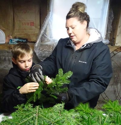 THIRD GENERATION WREATH-MAKER Savannah McPherson teaches her son, Lucas Scoville, the art of sculpting holiday greenery. “We tip our own brush and craft Christmas wreaths, centerpieces, swag