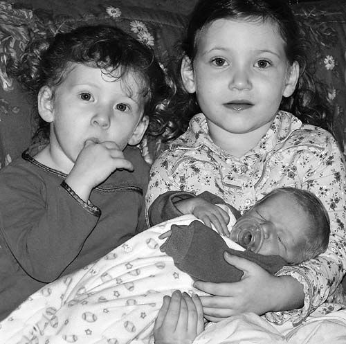 TWO NEW YEAR'S BABIES were born to Lubec parents this year. Holding new brother Zachary are sisters Summer and Skylar Sizemore. Jessie Ann Wormell also was born on New Year's Day. (Chessie J
