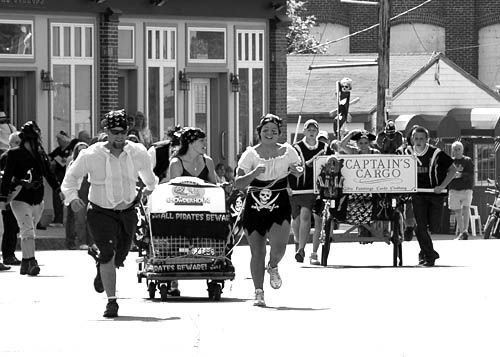 ALL HANDS TO THE CHASE! Racing toward the finish line during the Pirate Festival bed race on Sunday, September 9, are the Eastport Chowder House and Captain's Cargo teams. The latter was dec