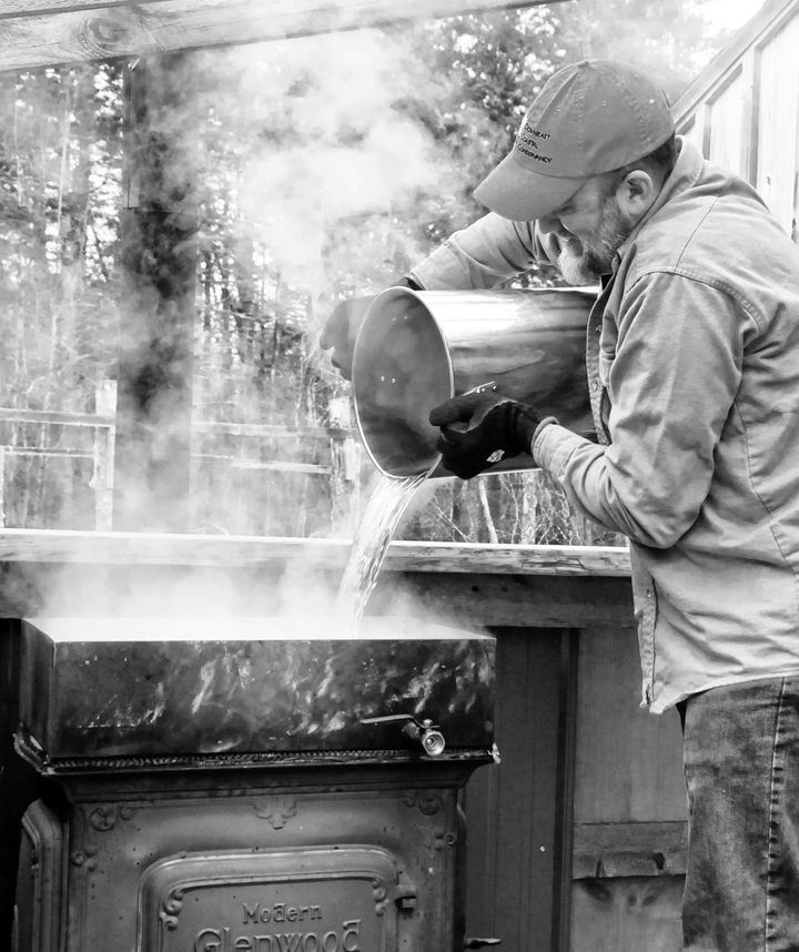 STEAM RISES as Colin Brown pours sap into an evaporator to make maple syrup at his home in Pembroke. (Edward French photo)