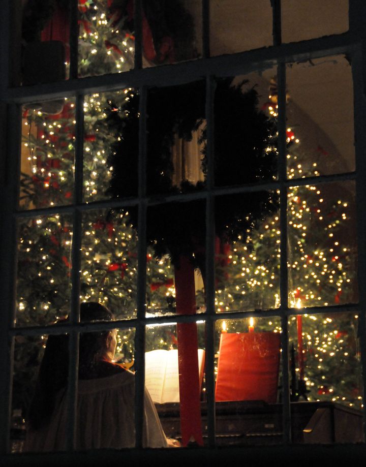 SHINING INTO THE DARKNESS are lights adorning one of the large Christmas trees in the Dennysville-Edmunds Congregational Church on December 18, as accompanist Christine Sawtelle plays during