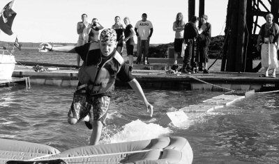 RUNNING THE CRATES instead of walking the plank during the Eastport Pirate Festival is Isaiah Chevrier of Eastport, who won the lobster crate race by crossing twice. (Donald Dunbar photo)