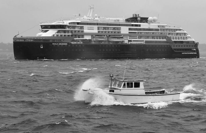 THE CRUISE SHIP ROALD AMUNDSEN comes in to dock at the Eastport breakwater during a wind-driven rain as Scott MacNichol goes by in his boat on September 20. The 459-foot Hurtigruten expediti