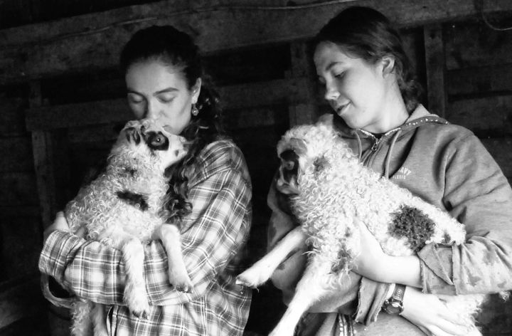 A SURE SIGN OF SPRING. These newborn lambs, two of perhaps a dozen that may be born this season at Shofar Farms in Perry, are embraced by Rebekah Guiltner (left), holding Tiny Tim, and her s