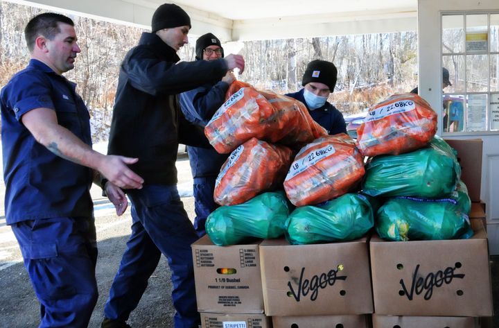 LENDING A HELPING HAND. U.S. Coast Guard personnel from Station Eastport help to carry in produce from the Good Shepherd Food Bank to the Labor of Love Food Pantry in Eastport, one of a numb