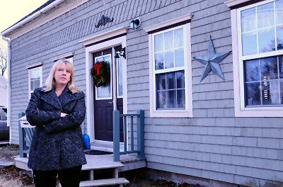 STANDING IN FRONT OF HER HOME that was foreclosed on by the city is Tobi McPhail of Eastport. She'll be able to get her deed back after two or three more months of payments, but others in th