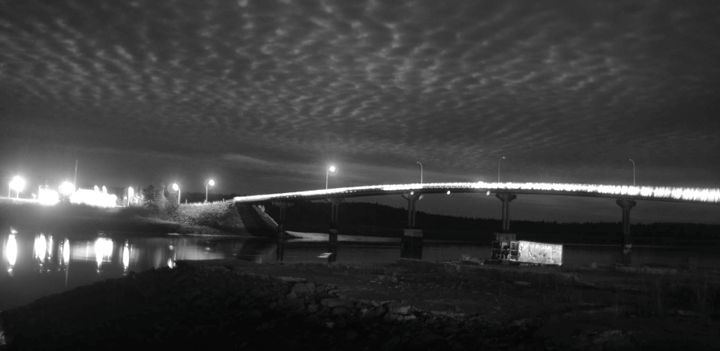 GLOW FROM THE CHRISTMAS LIGHTS installed by Joel Ross across the Franklin Delano Roosevelt Memorial Bridge between Lubec and Campobello reflects off the waters of the Lubec Narrows. (J.D. Ru