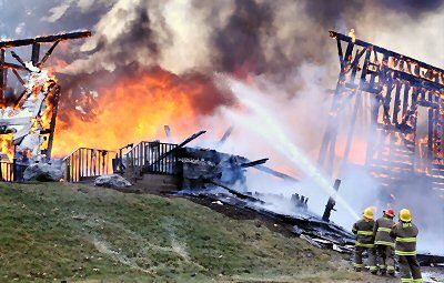 FIREFIGHTERS from the Dennys River Fire Department pour water onto the blaze that destroyed the historic First Baptist Church in Pembroke on October 29, during high winds from Hurricane Sand