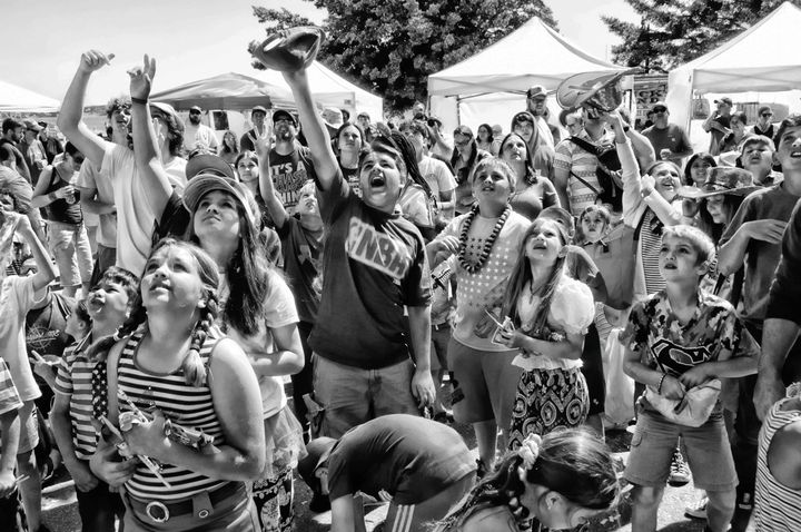 A JOYFUL WAVING FOURTH! During Eastport's 4th of July celebration, children reach up for prizes during the Penny Scramble, held every year in memory of Reid F. Craig, and also Peggy Davis th