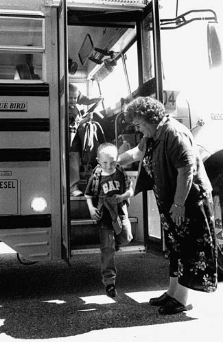 GREETED by Eastport Elementary School teacher Lillian Randall, K4 student Ryan Mullen steps off the bus for his first day of school on September 5. Drivers are reminded to watch out for chil