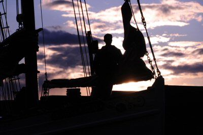 READY TO SET SAIL out to sea aboard the Sylvina W. Beal, as the sun sinks in the western sky, is crew member Darius Neptune. The Eastport-based windjammer is beginning its summer cruises thi