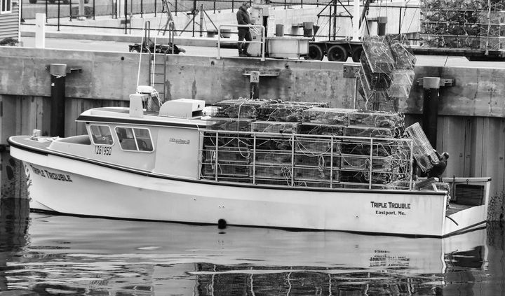 LOBSTER TRAPS are loaded onto the Triple Trouble at the Eastport breakwater on April 19, for setting at the start of this year's season. (Edward French photo)