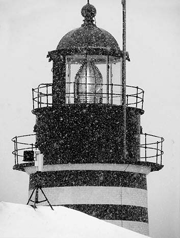 A SENTINEL IN A STORM, West Quoddy Head Light shines boldly through the flying snow. (Chessie Johnson photo)