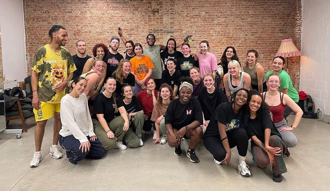 A group of 28 people looking toward the camera, smiling. Prince is in the middle in the back row.