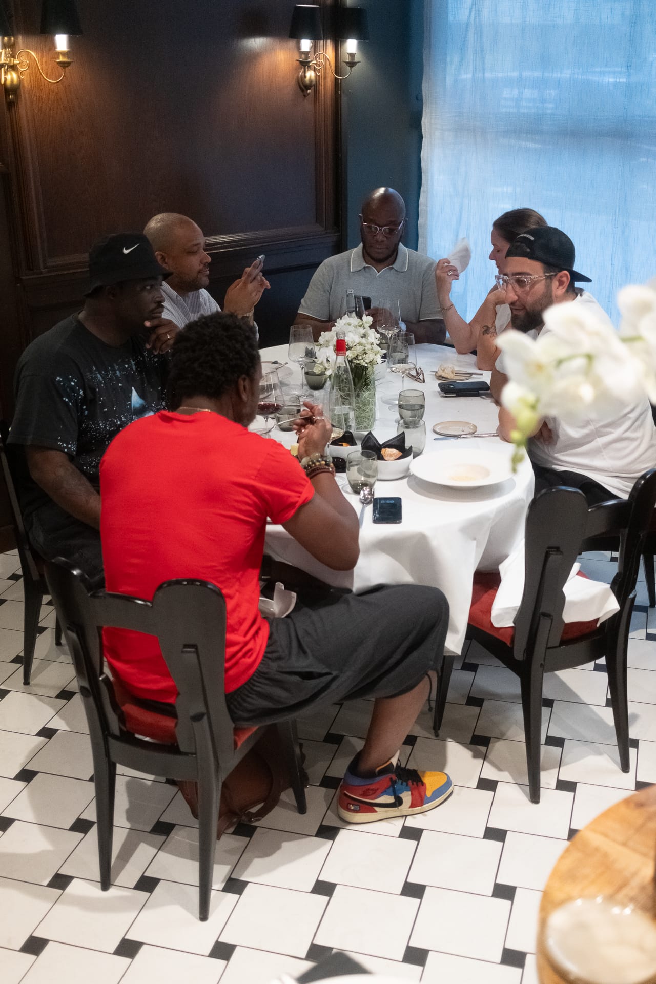Guests seated around a white tablecloth table at F.P. Journe Le Restaurant, enjoying food and conversation during the Super Niche event.