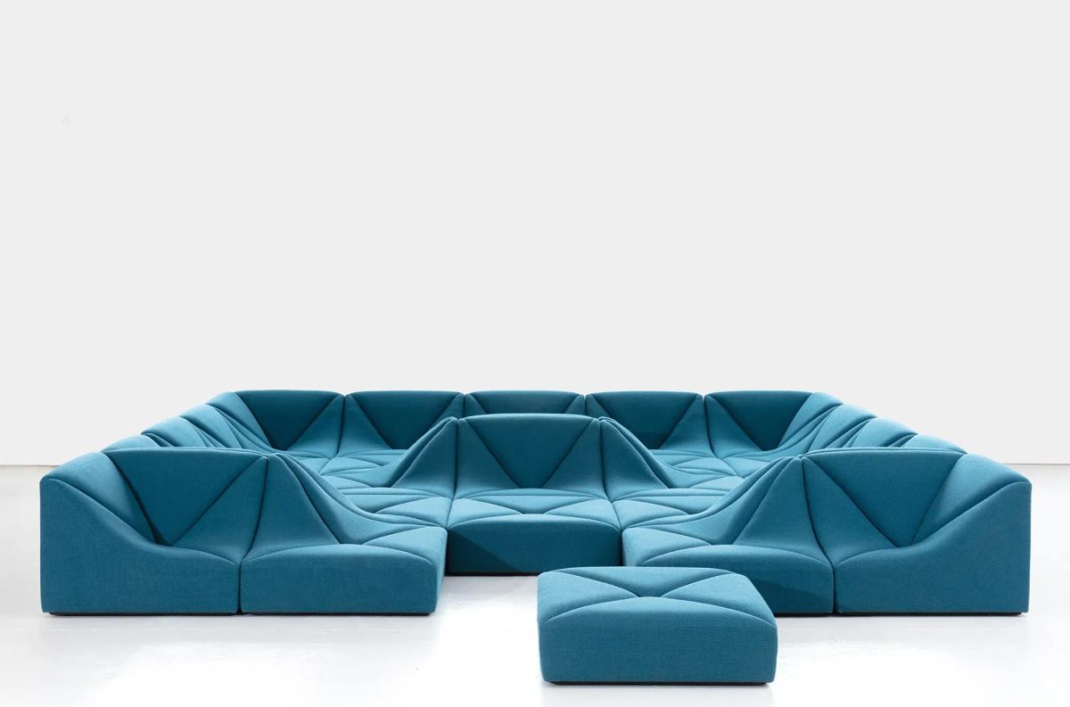 Modular blue sofa designed by Pierre Paulin, arranged in a sculptural circular composition against a minimalist white backdrop.
