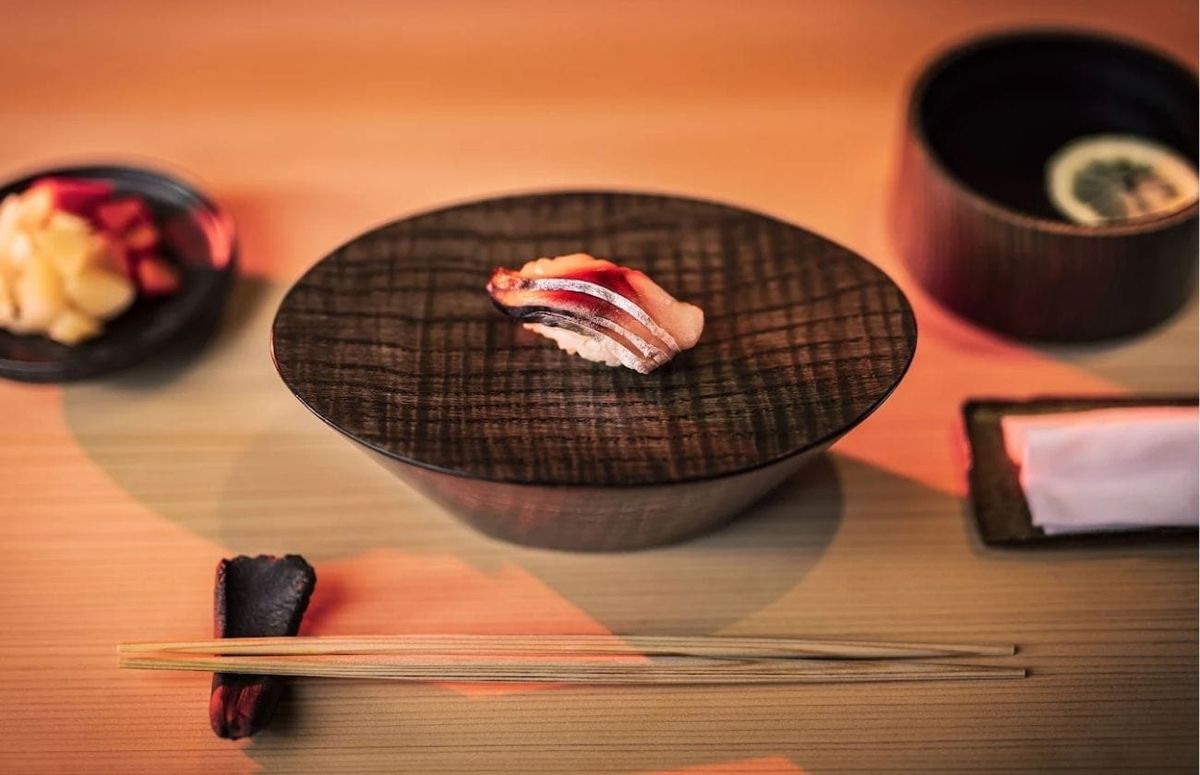 Nigiri served on a textured wooden plate at Yūgin, presented with minimalist tableware.