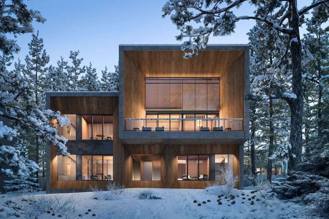 Modern timber-and-stone villa at Aman Niseko, set among snow-covered pine trees in Hokkaido, with warm interior light glowing through large windows at dusk.