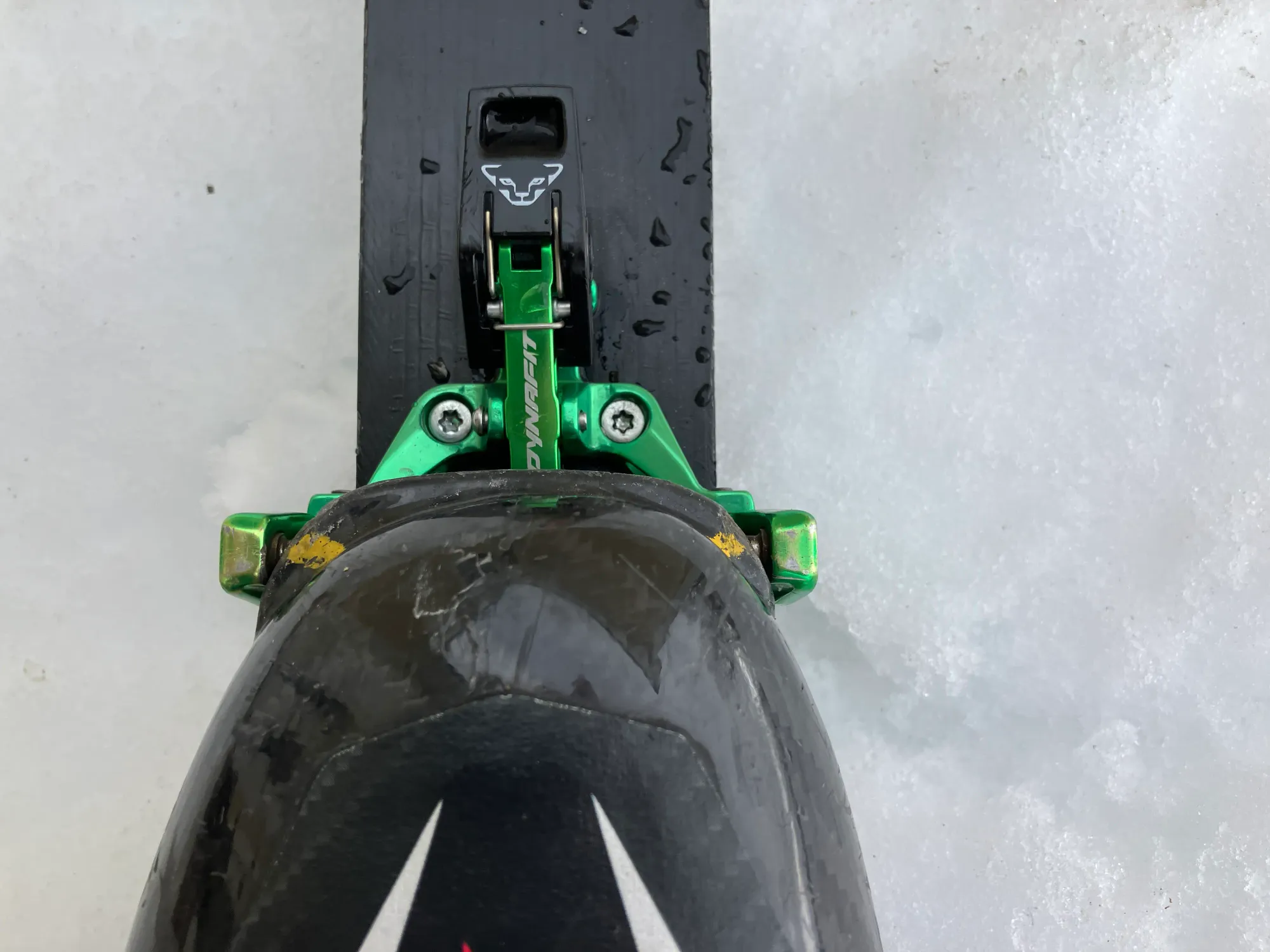 A top-view photo of the toe of a skimo boot in a binding with paint marks near the binding inserts.